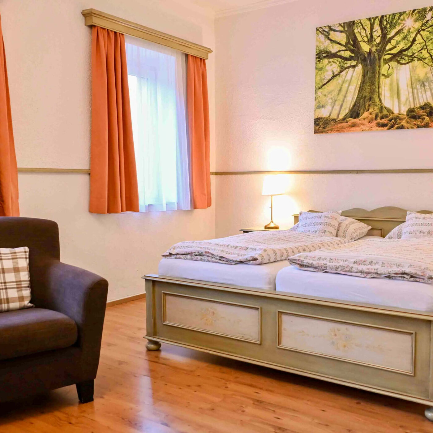 Ložnice apartmánu s dvojlůžkem, křeslem a oknem